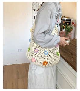 Detail of beige crochet tote bag featuring colorful handmade flower applique patterns