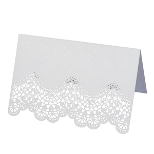 Detailed laser cut lace pattern on a white foldable wedding place card with pearlescent finish