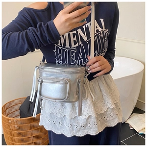 Détails du sac seau bandoulière argenté avec de longues franges et une finition métallique