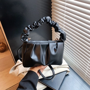 Detail view of the black pleated cloud bag with elegant ruched handle and PU leather texture