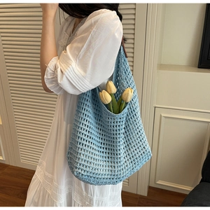 Close-up of sky blue crochet knit tote bag showing intricate hollow weave texture