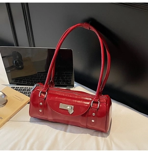Detail of red patent leather bowling bag featuring glossy finish and heart pendant
