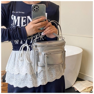 Détail du sac à main argenté métallisé avec plusieurs poches zippées sur le devant