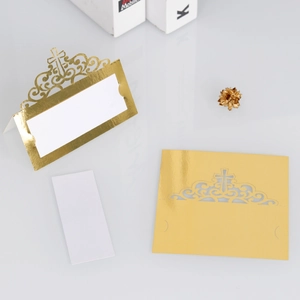 Detail of laser-cut cross hollow place card in mirror gold with white insert for weddings