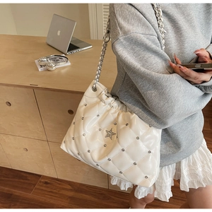 Détail du sac seau matelassé blanc avec cristal en étoile et bandoulière chaîne