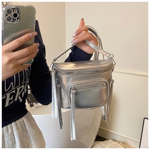 Gros plan du sac bandoulière argenté métallisé avec zips à franges et fine bandoulière