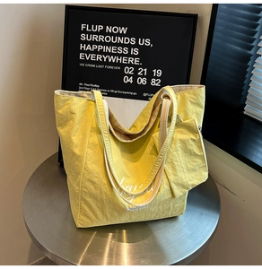 Detailed macro view of yellow large capacity tote bag with matching zippered pouch