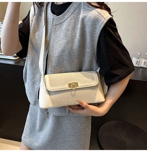 Detail of white woven leather shoulder bag featuring a gold ring twist-lock and shoulder strap