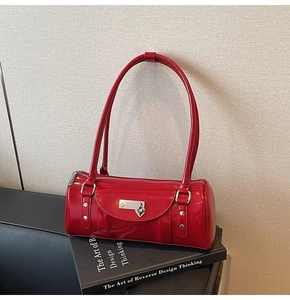 Close-up of red patent leather bowling bag with silver heart padlock and rivet detail