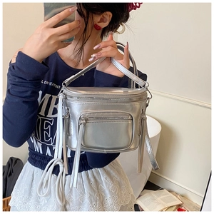Gros plan du sac seau argenté métallisé avec plusieurs zips et texture futuriste