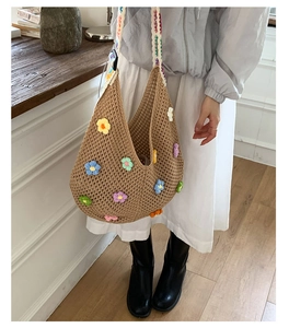 Detail of bohemian hollow knit tote bag with colorful crochet floral patches and shoulder strap