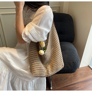 Detail of a brown crochet knit tote bag showing intricate hollow weave patterns