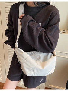 Minimalistische cremeweiße Dumpling-Tasche aus Nylon mit breitem Schultergurt