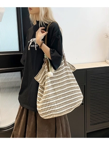 Large woven tote bag with contrast stripes and leather straps shown on model