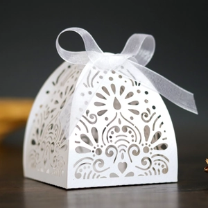 Elegant white laser-cut favor box with heart patterns and silk ribbon for weddings