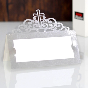 Detail of silver laser-cut cross wedding place card with elegant hollow pattern