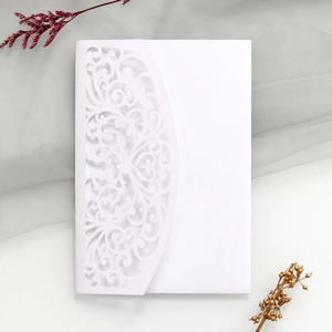 Detailed laser-cut white wedding invitation with elegant baroque hollow patterns