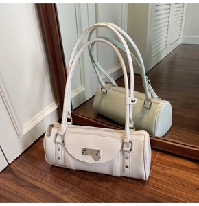 Detailed mirror shot of cream white Boston bag with heart charm and silver metal lock