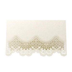 Close-up of laser-cut lace texture on pearlescent ivory wedding name place card