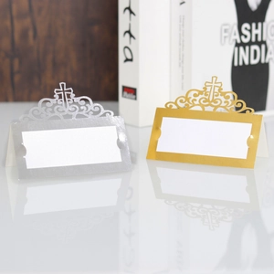 Macro view of gold laser-cut table card featuring an intricate hollow cross and scrollwork