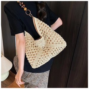 Detailed close-up of handmade beige woven tote bag with artistic wood bead shoulder straps