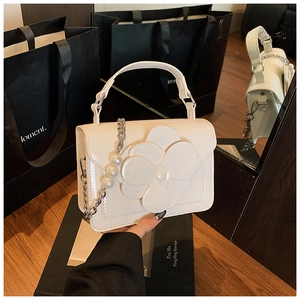 Detail of white floral crossbody bag with 3D flower decoration and pearl chain strap
