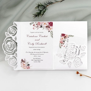 Close-up of laser-cut rose hollow invitation with elegant floral cards for wedding events