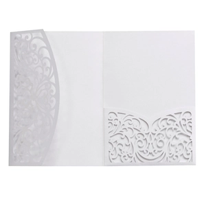Elegant white laser cut wedding invitation with intricate lace hollow patterns on cardstock