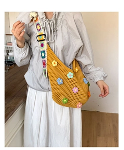 Close-up of yellow crochet beach bag with colorful handmade 3D floral knit decorations