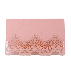 Detail of laser-cut lace pattern on pink glitter wedding place card with pearlescent finish