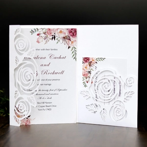 Detail of laser-cut rose hollow pattern on white wedding invitation set