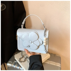 Detail of light blue floral handbag with 3D leather flower and pearl chain strap