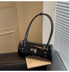 Detail of a black shiny bowling bag with silver heart lock on a vintage book background