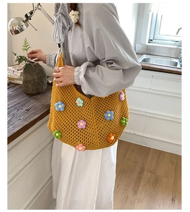 Close-up of yellow crochet knit tote bag with colorful 3D floral embroidery details