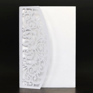 Macro view of white laser cut floral patterns on pearlescent paper invitation cover