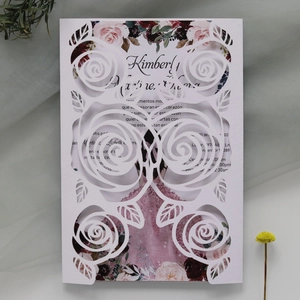Detailed view of laser-cut white rose invitation cover with floral printed card
