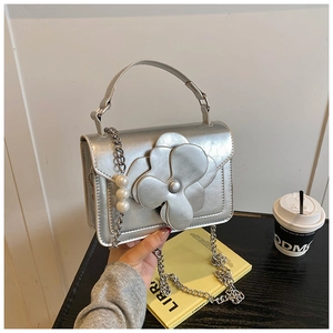 Silver floral handbag with detailed metallic flower and pearl accents on the chain strap
