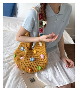 Detail of bohemian hollow knit tote bag with 3D floral accents and wide geometric strap