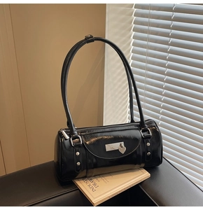 Close-up of black glossy bowling bag featuring silver heart pendant and stud details