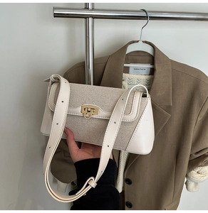 Detail of cream woven shoulder bag with golden metal twist lock and smooth leather texture