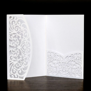 Detail of white laser-cut wedding invitation featuring intricate European floral patterns