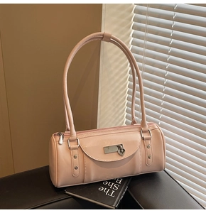 Detailed macro view of pink patent leather bowling bag with heart charm and long strap