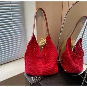 Detail of red hollow knit tote bag with brown leather shoulder strap and rivet