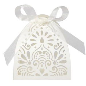 Detail view of white laser-cut wedding favor box with an elegant satin ribbon bow