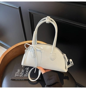 Detail of white half-moon bag with lychee texture PU leather and bow drawstring