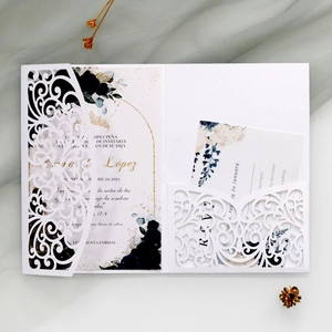 Detailed laser-cut wedding invitation set with navy floral print and elegant gold borders