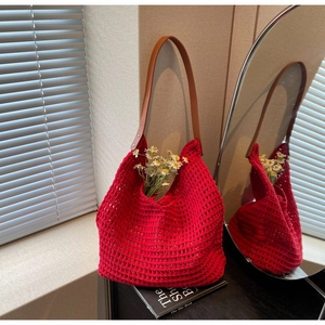 Detail of red hollow knit tote bag featuring premium brown leather shoulder straps