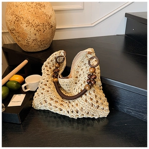 Close-up of woven straw tote bag featuring handcrafted round wooden bead handles