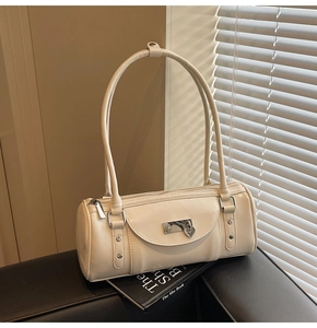 Close-up of cream bowling bag with glossy finish and silver heart charm detail