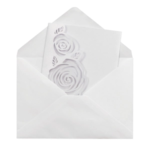 Macro shot of white laser-cut rose floral wedding invitation with matching envelope